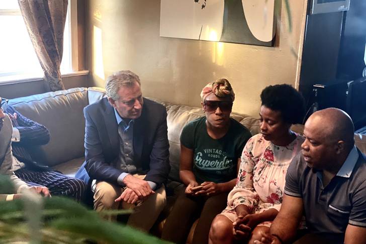de Blasio sits on a couch with relatives of Justin Wallace